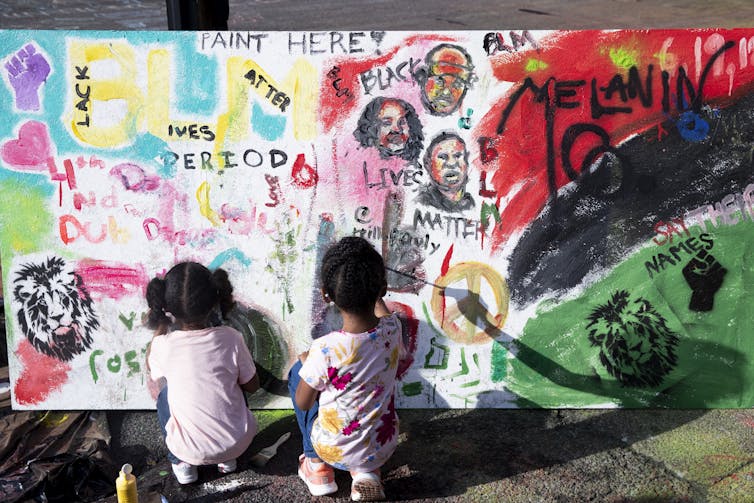 Two children paint a mural at Black Lives Plaza, Washington D.C. AAP/EPA/Michael Reynolds
