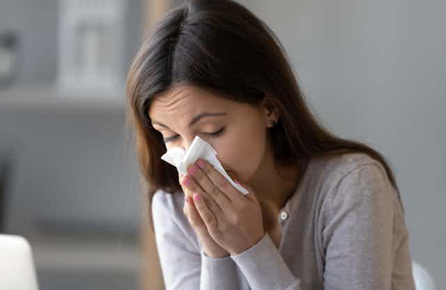 Woman blowing her nose with a tissue