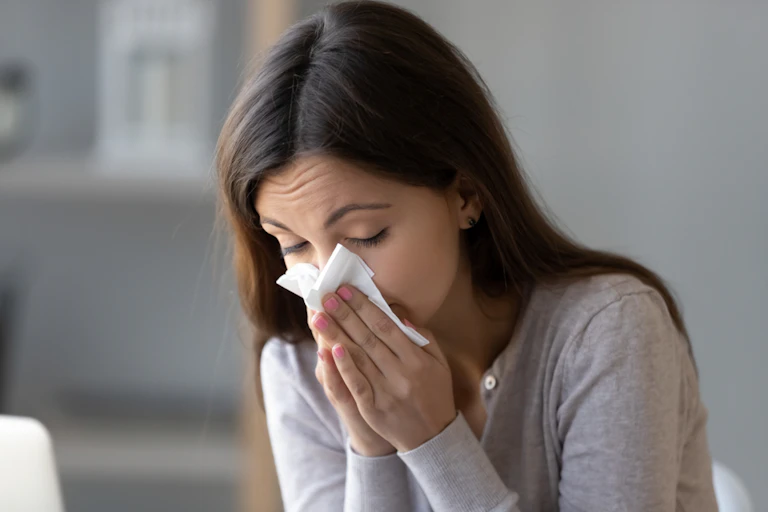 Woman blowing her nose with a tissue