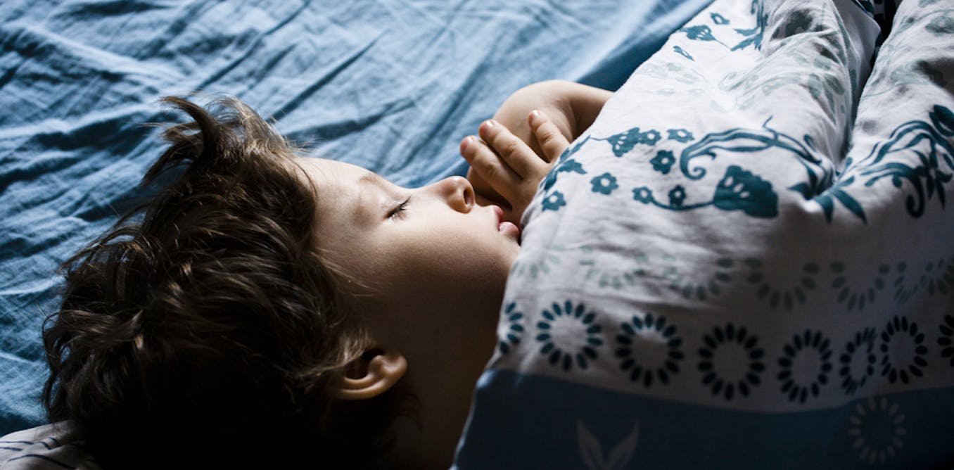 Мальчик спит в кровати