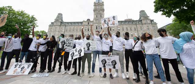 Youth stand in a line singing at a demonstration to denounce racism and police violence, June 7, 2020 in front of the legislature in Québec City. 