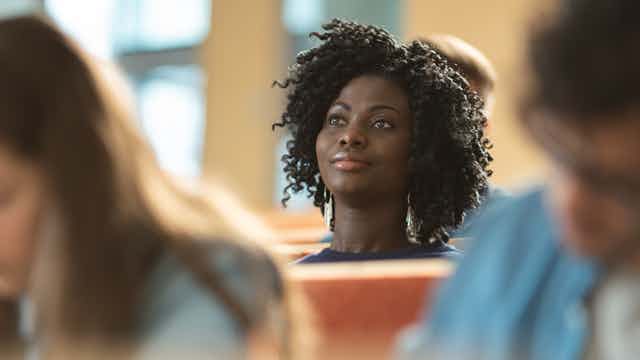 A black woman student focuses her attention in class.
