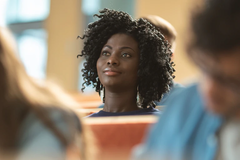 A black woman student focuses her attention in class.
