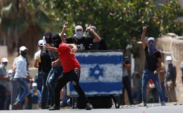 Palestinian protesters throw rocks at Israeli troops