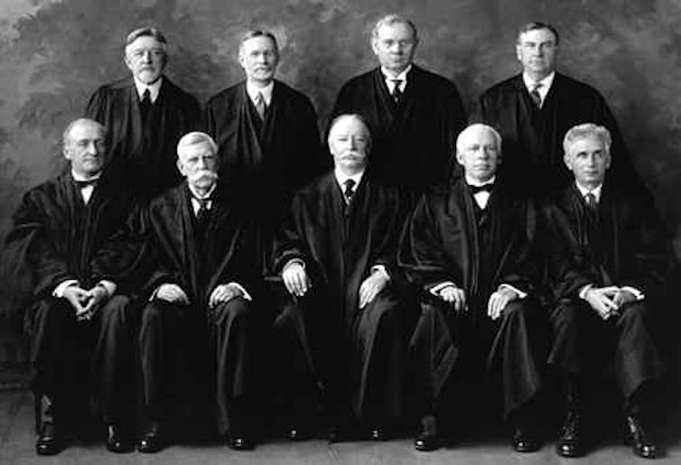 Nine men in black judges' robes.