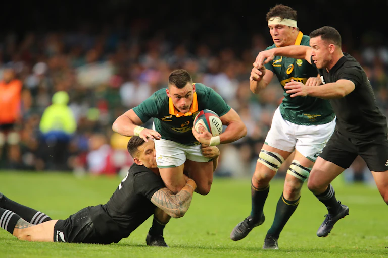 'Rugby player with ball gets tackled'