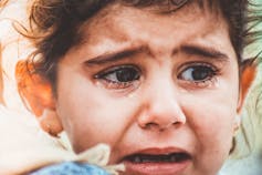 A young girl weeps.