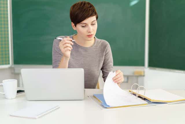 Female teacher with file and laptop