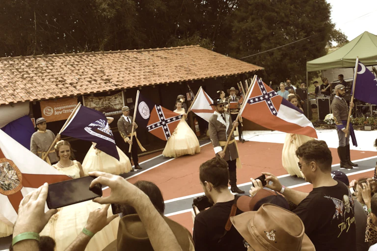 People in Civil War clothing hold Confederate flags
