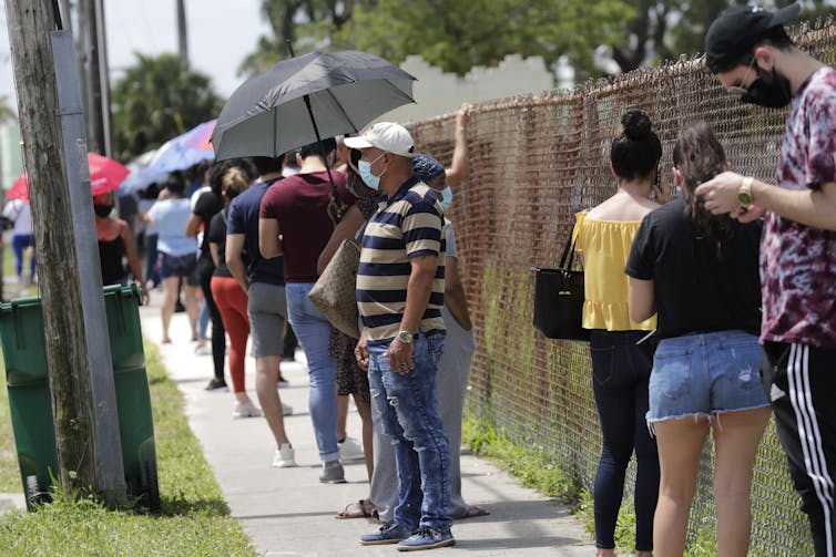 In Florida, people wait outside a COVID-19 testing station.