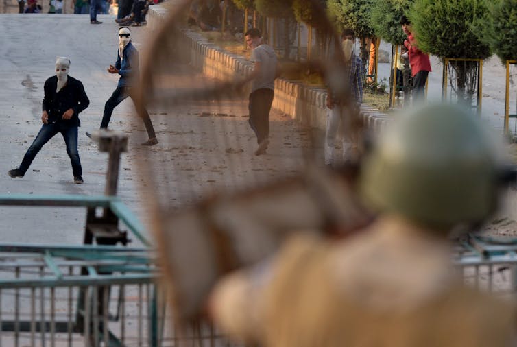 Soldier with a shield faces off against angry civilians