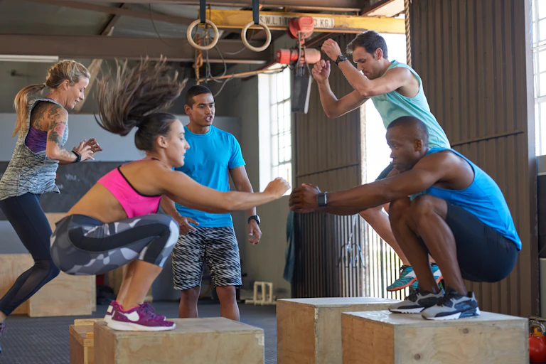 'Five fit adults perform HIIT box jumps'