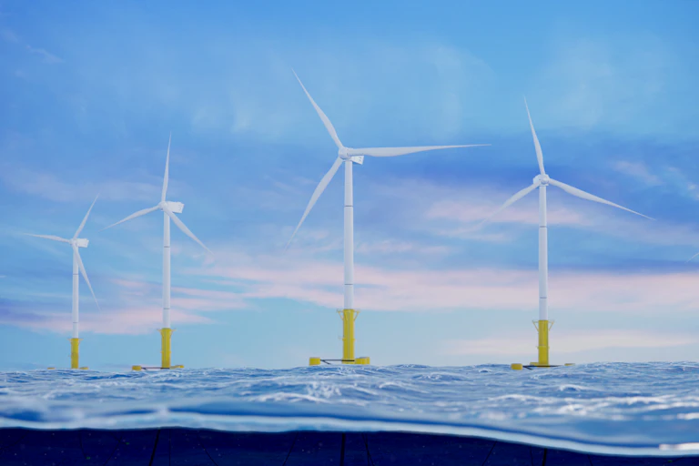 A row of floating wind turbines at sea.