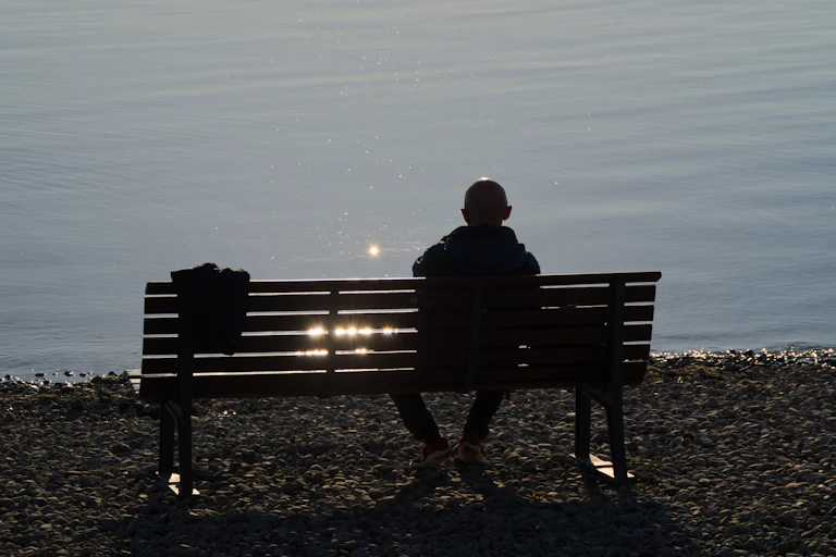 Image of a man sitting alone on a bench.