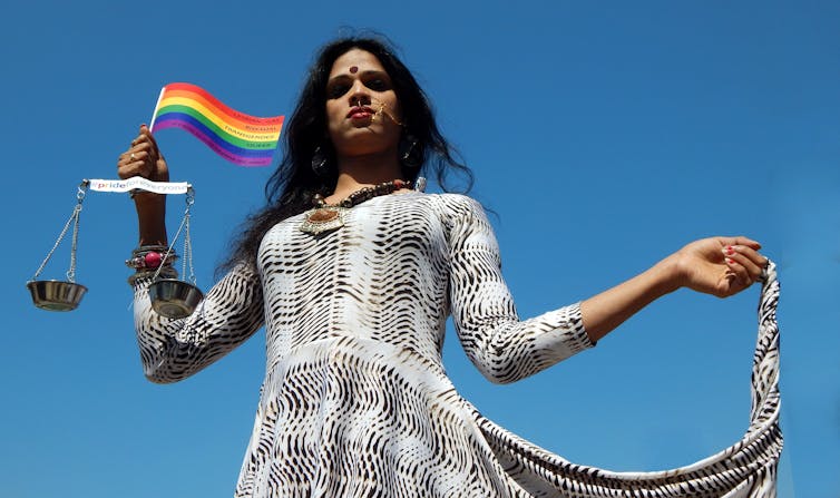 LGBT activist holding flag and scales of justice