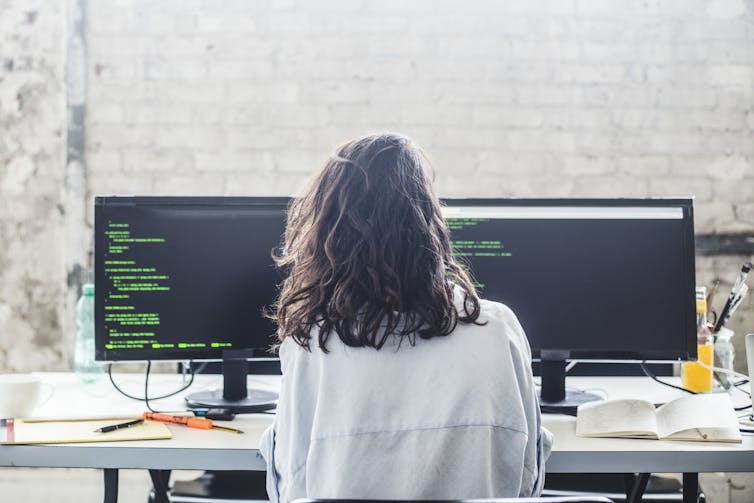 person working at computer screens