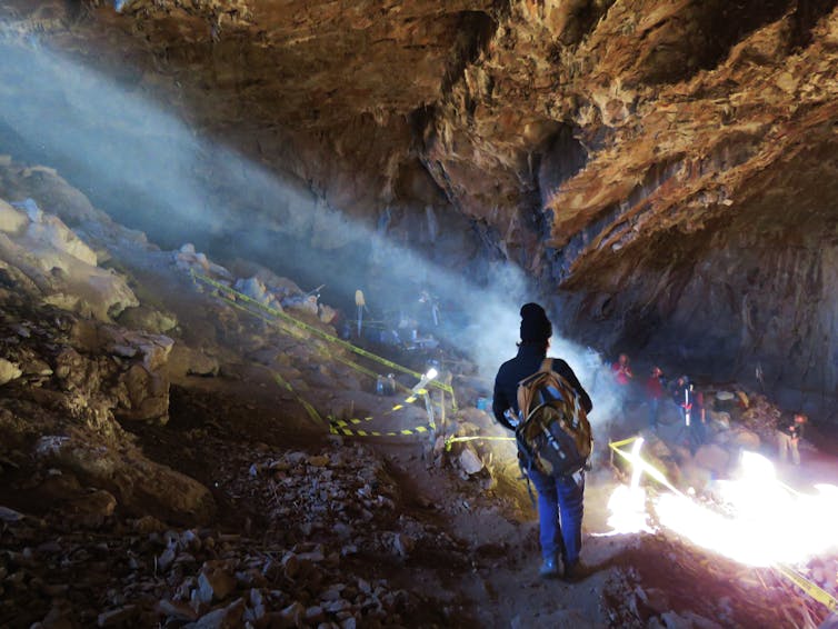 A woman walking into a cave