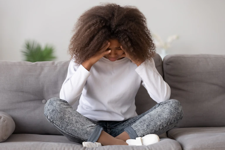 Young black woman with head in hands