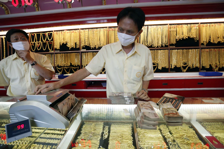 Shopkeepers in a jewellery shop wearing masks.