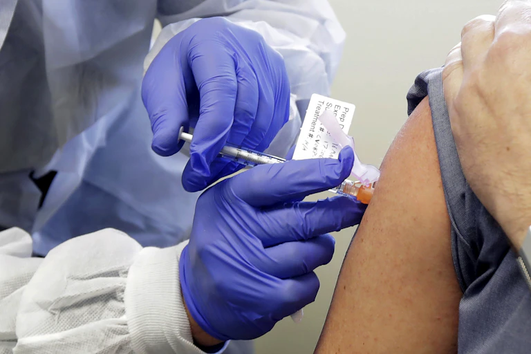 A patient receives a shot in the first-stage safety study clinical trial of a potential vaccine for COVID-19 in March at the Kaiser Permanente Washington Health Research Institute in Seattle.