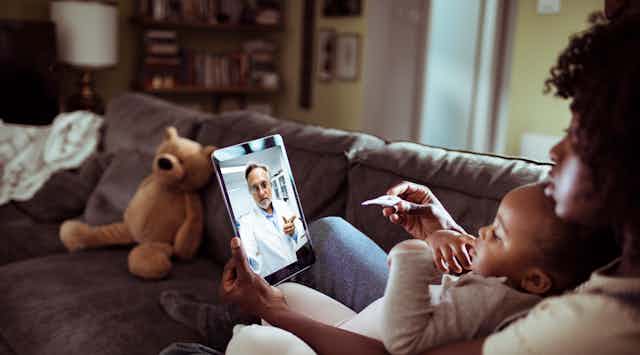Woman with baby talking to doctor through a video chat.