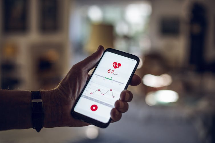 Man holding phone with health data.