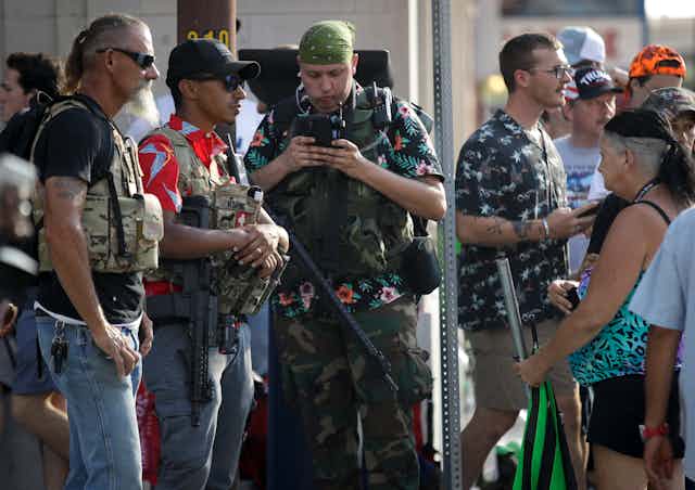 Members of the boogaloo movement. Three men feature prominently in the picture wearing fatigues and Hawaiian shirts. 