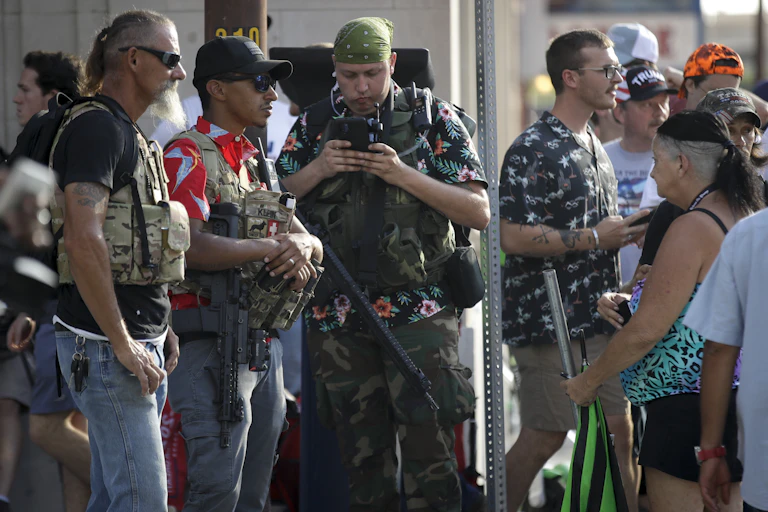 Members of the boogaloo movement. Three men feature prominently in the picture wearing fatigues and Hawaiian shirts.
