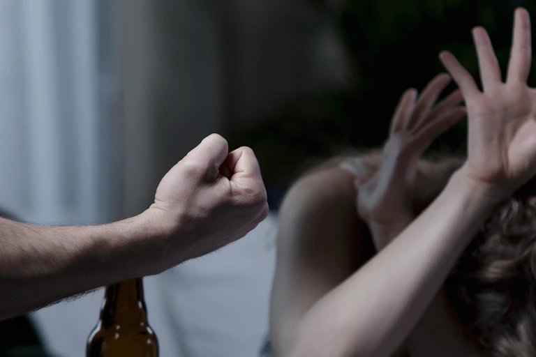 Man threatens woman with his fist while woman cowers.