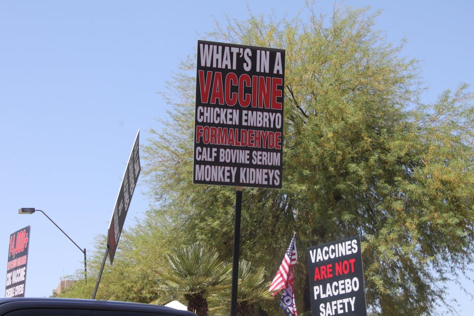 Trump supporters rallying to 'reopen' the economy from COVID-19 safety restrictions carry signs with anti-vaccination myths.