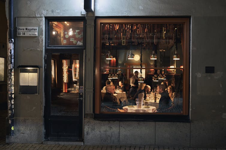 People sit at tables inside a small restaurant