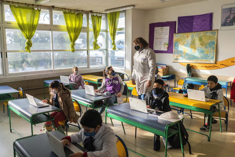 Students and a teacher wearing face masks in a classroom