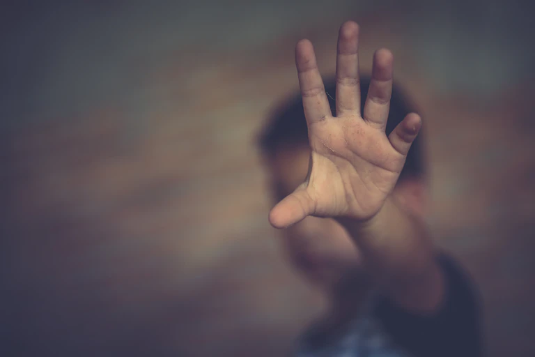Boy holding his hand up in a stop sign