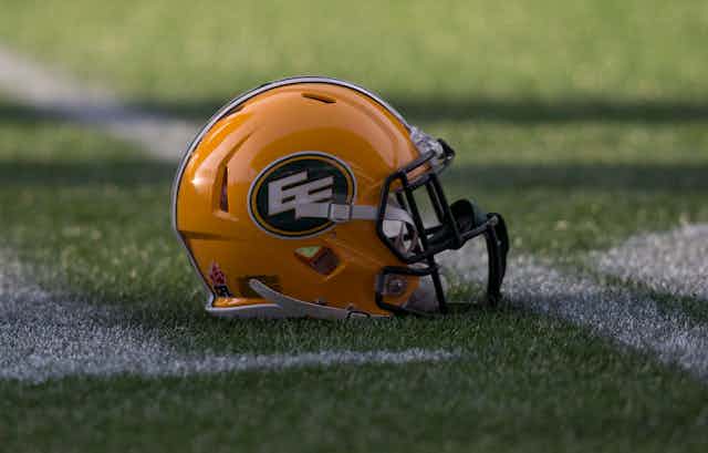 An Edmonton Eskimos football helmet lies on the playing field.
