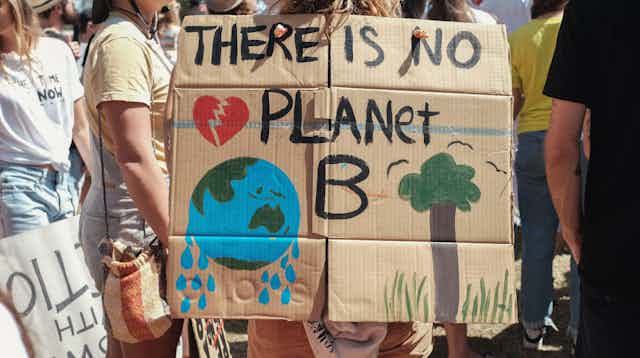'There is no planet B' is written on a cardboard sign at a protest.