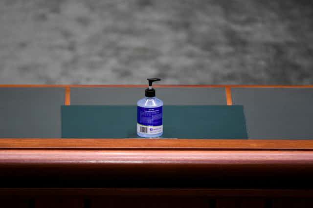 A bottle of hand sanitiser on a House of Representatives table