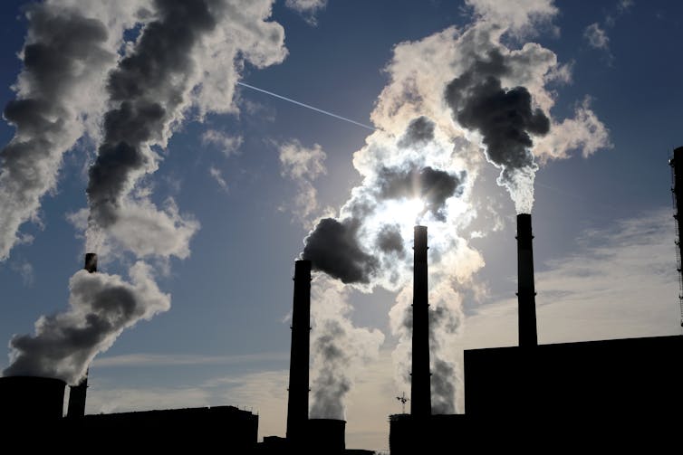 The silhouette of a coal-burning power plant.