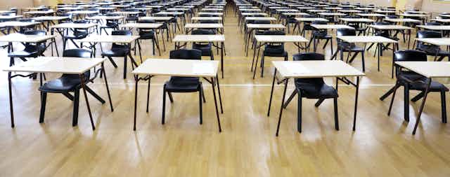 A large exam hall with desks and empty chairs