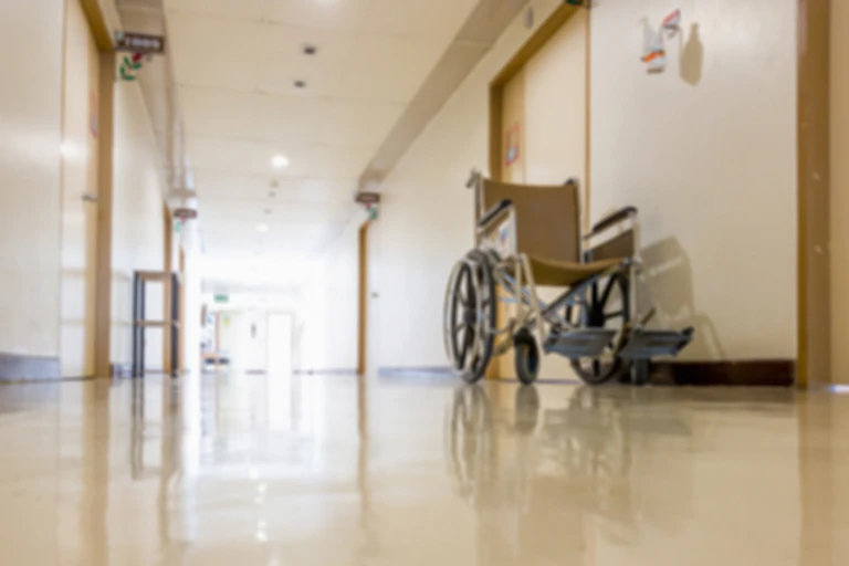 An empty wheelchair sits in the hallway of an aged care facility.