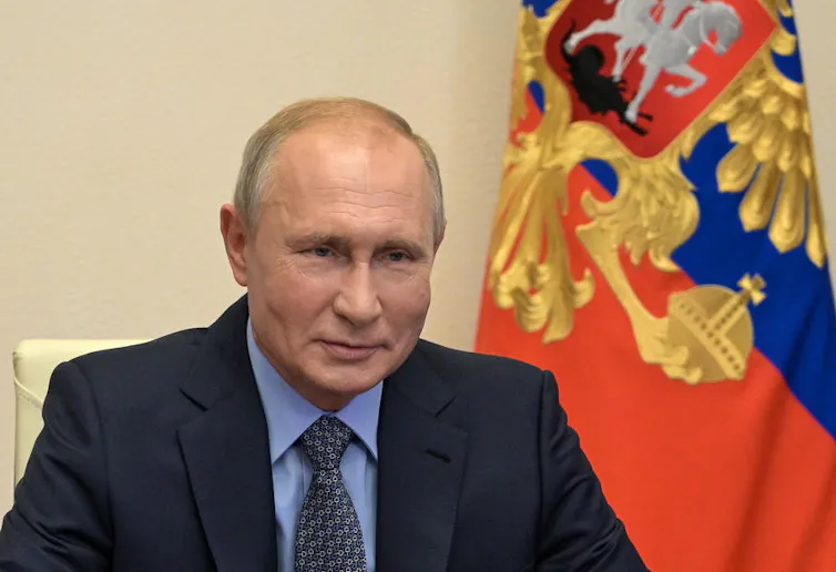 Vladimir Putin with flag behind him