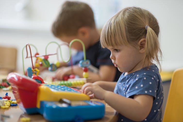 Little girl playing with toy at nursery