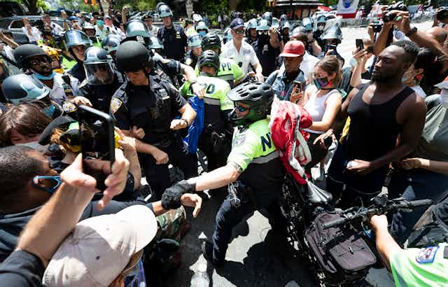 Police officer grabs Black Lives Matter protester among crowd