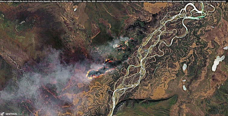 A full-colour satellite image of multiple fires burning in a forested river valley