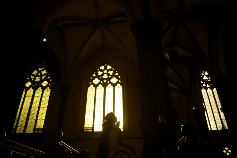 Inside a church, with glowing stained glass windows