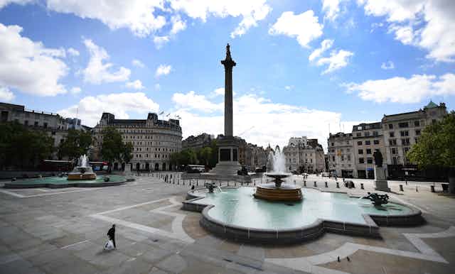 Lone person walks across empty Trafalgar Square in London