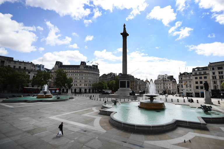 Lone person walks across empty Trafalgar Square in London