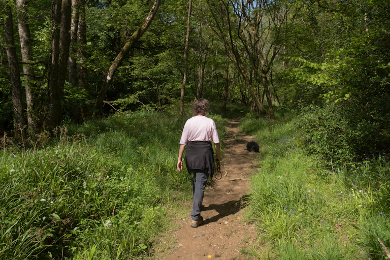 Woman walking her dog in woods