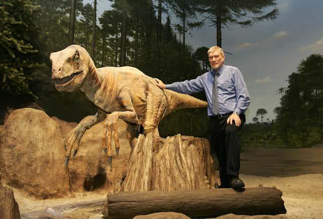 Man stands with robotic dinosaur