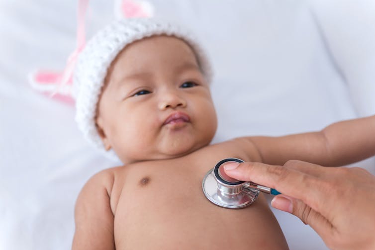 A newborn baby is examined by a doctor