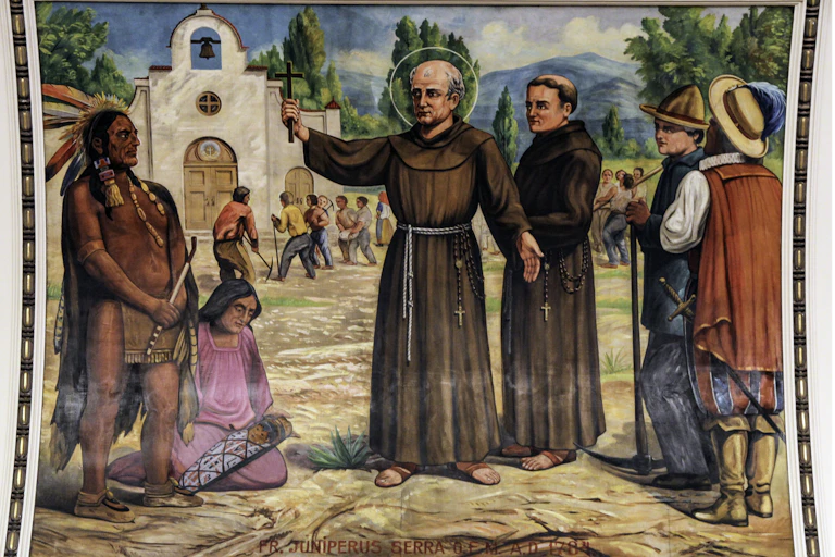 Monks show a cross to Native people